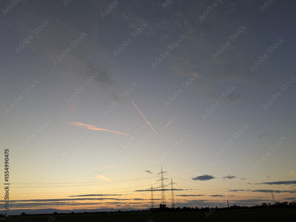 Airplane contrails glowing in warm sunset colors across a dramatic sky, creating dynamic lines of light above the horizon.
Airplane contrails glowing in warm sunset colors across a dramatic sky, creating dynamic lines of light above the horizon.