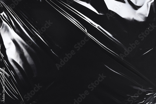 Black plastic wrap texture features creases and folds creating shadows and highlights for a realistic wrinkled effect