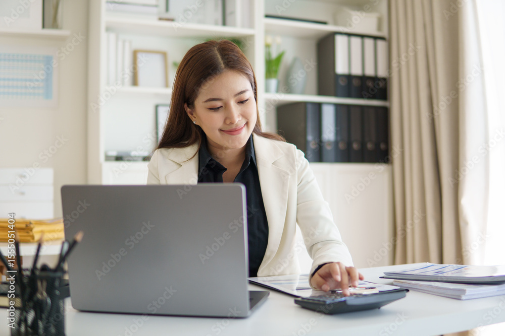Businesswoman using a calculator and working on financial documents at modern office desk. Businesswoman using a calculator and working on financial documents at modern office desk.