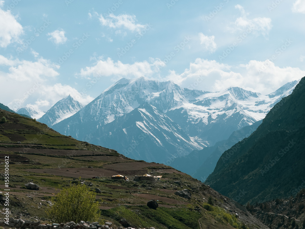 Fototapeta premium Clouds above the snow covered mountain peak at Miyar valley in Himachal Pradesh, India. Summer mountain landscape. Nature background. Travel and holidays concept.