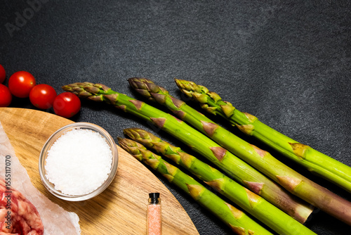 Fresh vegetables and seasonings arranged on a wooden board for meal preparation
