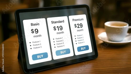 A tablet displays three pricing cards for Basic, Standard, and Premium plans on a wooden table. Concept of subscription tiers.