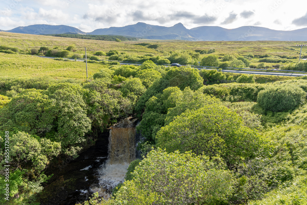 Obraz premium The Isle of Skye, is a large and scenic island in the Inner Hebrides of Scotland.Carved by the River Lealt, the Lealt Falls plunge 90 metres down a narrow, tree-lined gorge into the Sound of Raasay. 