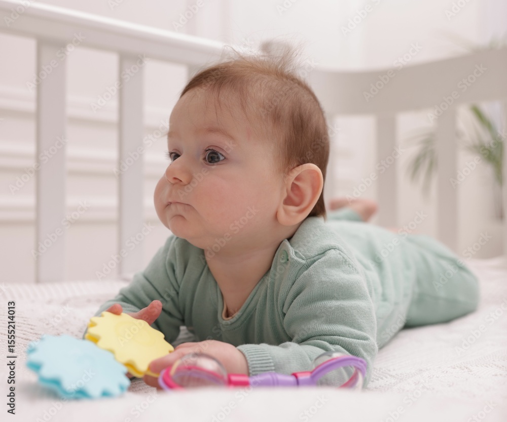 Cute little baby with rattle toy in crib at home Cute little baby with rattle toy in crib at home