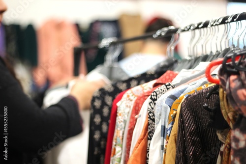 roupas em cabideiro em feira de segunda mao, consumo conciete de produtos texteis em economia circular.
