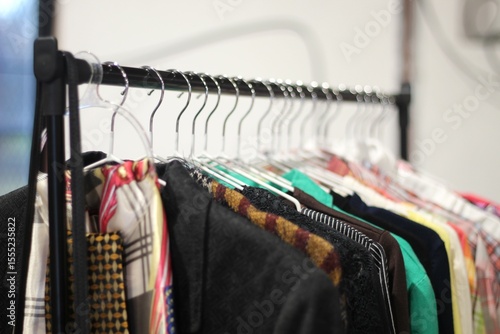 roupas em cabideiro em feira de segunda mao, consumo conciete de produtos texteis em economia circular.