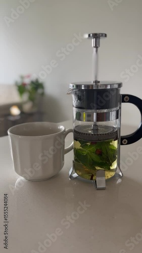French press and tea cup on marble table with cozy home background