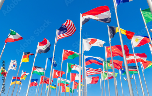 World congress countries national flags waving together on the wind, with American, Japanese, Omani, Chinese, Russian, Iraqi, Egyptian banners in the foreground, Doha, Qatar