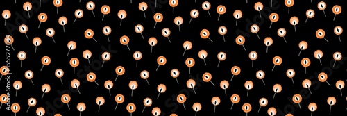 Seamless Halloween pattern with orange eyeball lollipops scattered on a black background in a playful spooky style. Fun Halloween Treats. Orange Eyeball Candy Repeat Design