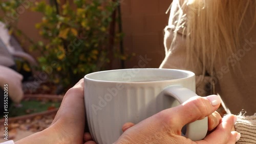 Two hands exchange a tea cup, side angle, peaceful fee