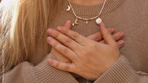 A woman meditates with her arms crossed over her chest