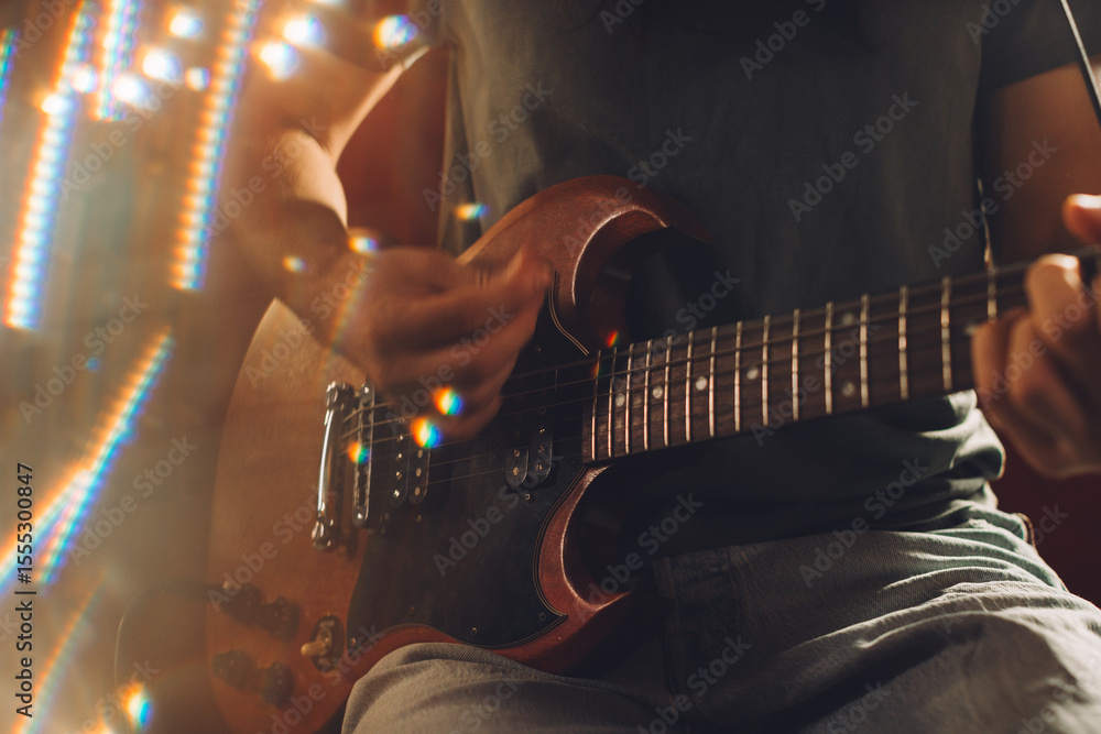 Obraz premium Musician playing electric guitar in recording studio with lens flare
