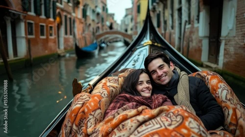 A young Caucasian couple sits in a gondola, wrapped in a blanket, smiling at each other. The backdrop features Venetian architecture and a serene canal.