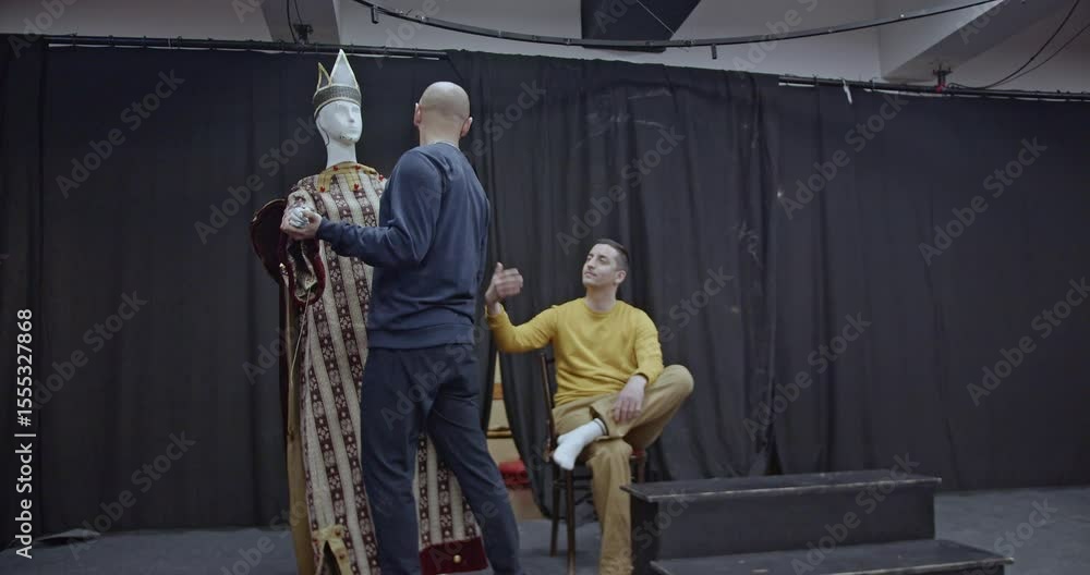 Actor Taking Direction Two actors rehearse a scene on a theater stage. One actor gives ...