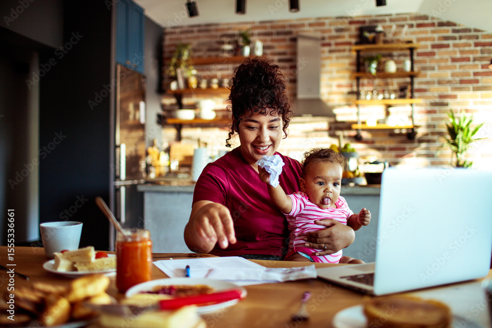 Work from home mom with baby on video call in kitchen Work from home mom with baby on video call in kitchen