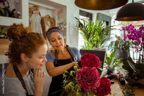 Mother and daughter florists working with flower arrangement in a shop