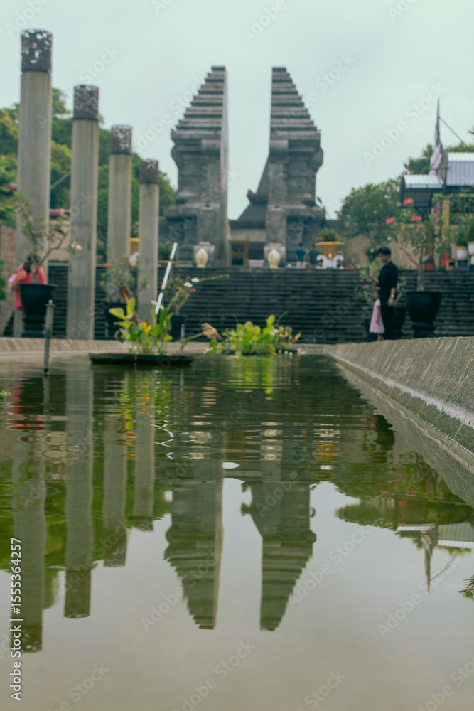 Naklejka premium Soekarno’s Tomb Entrance with Serene Fish Pond and Lush Garden on Sunny Day