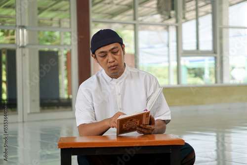 Bild auf Leinwand Asian moslem man read holy book at mosque show faith believe to god