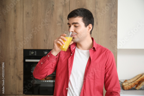 Young man drinking orange j...