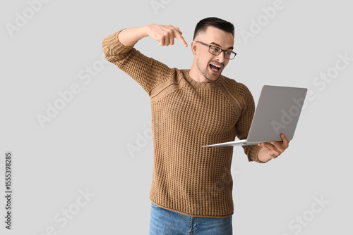 Happy young man pointing at...
