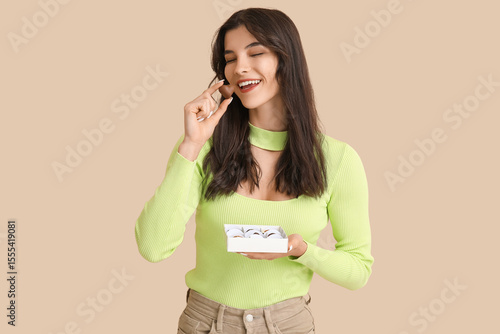 Happy young woman with box ...
