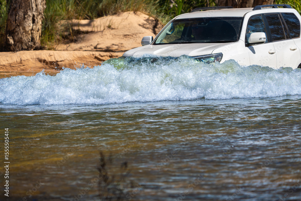 Obraz premium 4x4 vehicle driving through or across riveron expedition in Western Australian outback