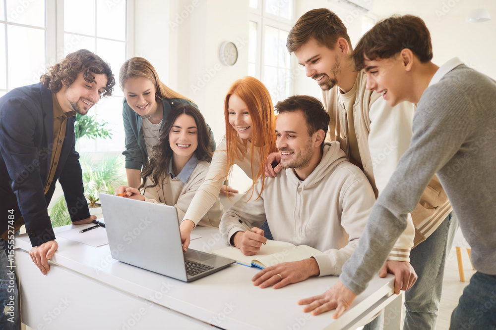 Young people discussing job project or new startup with brainstorming standing on workplace in office. Company employees or college students working with laptop. Teamwork and education concept. Young people discussing job project or new startup with brainstorming standing on workplace in office. Company employees or college students working with laptop. Teamwork and education concept.