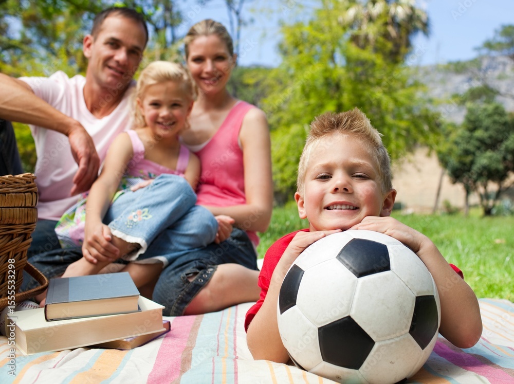 Little boy having fun with a soccer ball with his family smiling Little boy having fun with a soccer ball with his family smiling