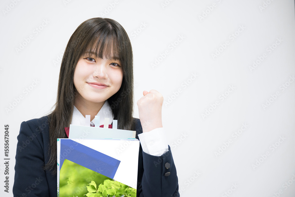 塾や予備校などの大学受験イメージ教科書を持つ女子高生 ガッツポーズ 塾や予備校などの大学受験イメージ教科書を持つ女子高生 ガッツポーズ