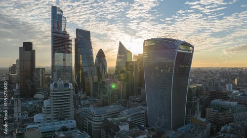 Modern iconic high rise buildings in City business and financial hub against colourful sunrise sky. Aerial hyperlapse morning footage. London, UK