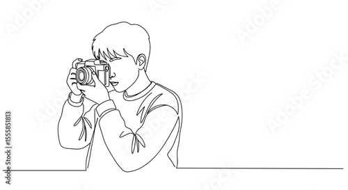 Boy using old film camera while focusing on a photo shoot  