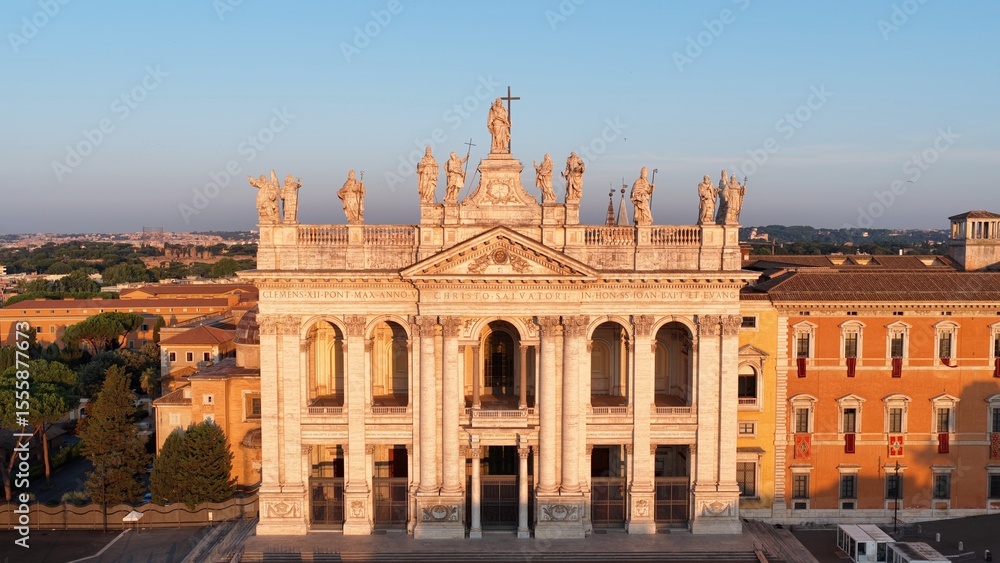 Fototapeta premium La basilica di San Giovanni in Laterano e le statue dei santi. Roma, Italia. Vista aerea delle statue dei santi sul tetto della basilica di San Giovanni in Laterano a Roma.