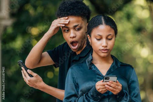 Obraz na plátně couple spying on cell phone
