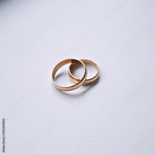 Two gold wedding rings are placed on a white background