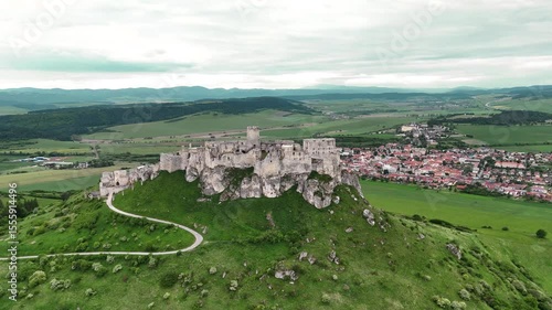 Cinematic 4K drone shot rising above and away from medieval castle ruins in Slovakia. Reveals surrounding landscape. No audio.