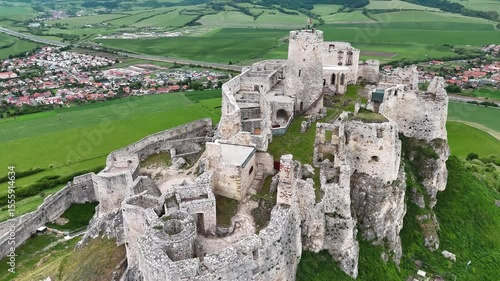 Cinematic 4K drone flying along and above medieval Slovak castle ruins. Smooth vertical motion over structure. No audio.