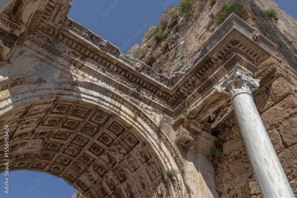 Obraz premium The Arch of ancient times. The famous gate, built in honor of the ancient Roman emperor. The Arc de Triomphe in the Kaleici area. Hadrian's Gate in Antalya. The arch is decorated with carved patterns.