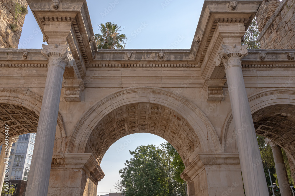 Obraz premium The Arch of ancient times. The famous gate, built in honor of the ancient Roman emperor. The Arc de Triomphe in the Kaleici area. Hadrian's Gate in Antalya. The arch is decorated with carved patterns.