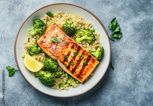 Grilled salmon served with fresh broccoli and quinoa on white plate, isolated view