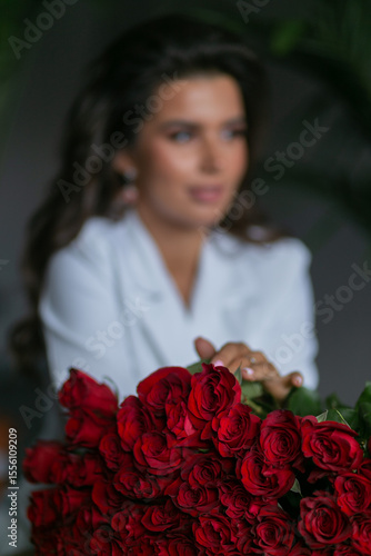 Foto beautiful mulatto woman with a large bouquet of scarlet roses