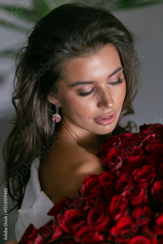 Bild auf Leinwand beautiful mulatto woman with a large bouquet of scarlet roses
