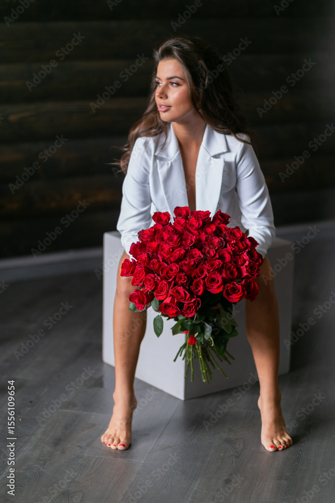Fototapeta premium beautiful mulatto woman with a large bouquet of scarlet roses