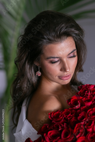 Bild auf Leinwand beautiful mulatto woman with a large bouquet of scarlet roses