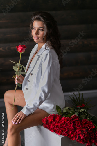 Bild auf Leinwand beautiful mulatto woman with a large bouquet of scarlet roses