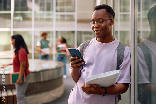 Tableau sur toile Happy black student using smart phone at university campus.