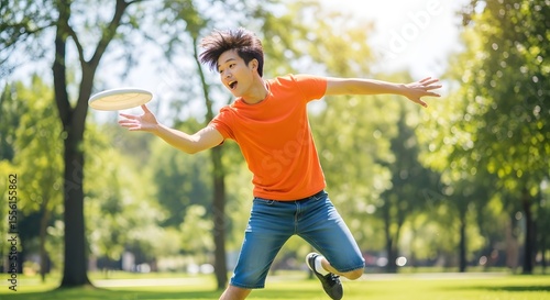 Energetic youth catches a frisbee midair in a sunlit park