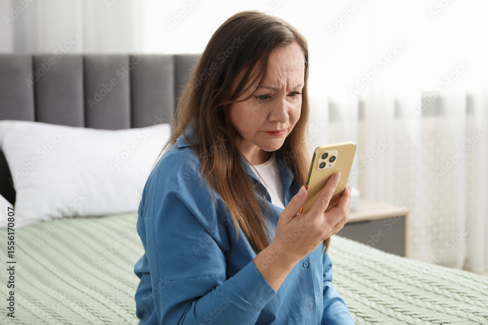 Woman with vision problem using smartphone on bed at home Woman with vision problem using smartphone on bed at home