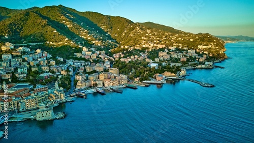 Wide aerial panorama of Rapallo and sweeping Ligurian coastline bathed in warm evening light on the Italian Riviera, Italy	