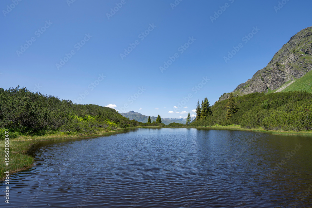 Fototapeta premium blue mountain lake Wiegensee with fantastic view in Partennen Gaschurn Montafon in Vorarlberg Austria with negative space for text