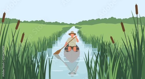 Man paddling a canoe through a narrow waterway surrounded by tall reeds and green fields under a clear sky